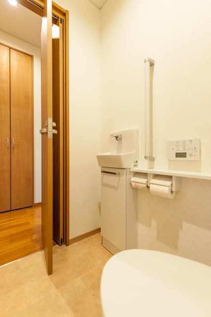 省スペースで開閉できる連動折れドアのトイレ事例、介助しやすい開口設計