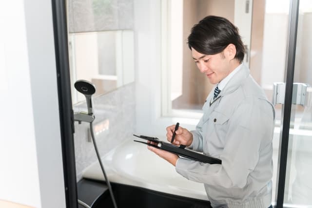 リフォーム業者がユニットバスのサイズ提案のために事前の下見・調査をしている様子