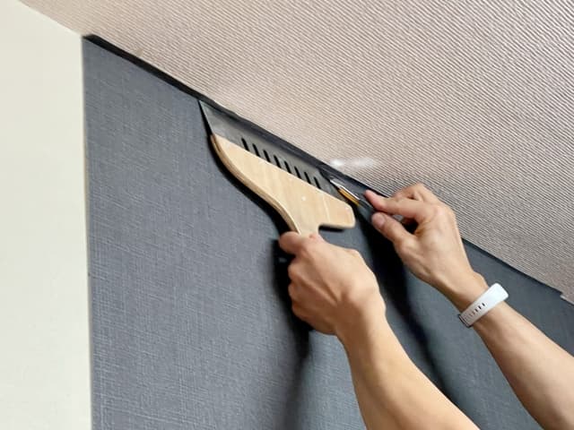 クロス張り替え作業を行っている職人の手元を映した画像