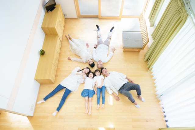 床暖房リフォームのイメージ（床で寝転ぶ家族のいるリビング）