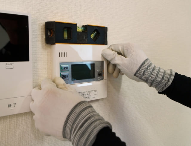 給湯器の交換はどこに頼む？専門業者による室内リモコンの丁寧な取り付け作業の様子