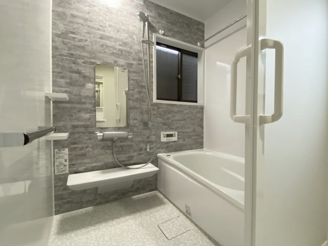 モダンな内装と清潔感のある白い浴槽が特徴的な、広々としたお風呂場のリフォーム