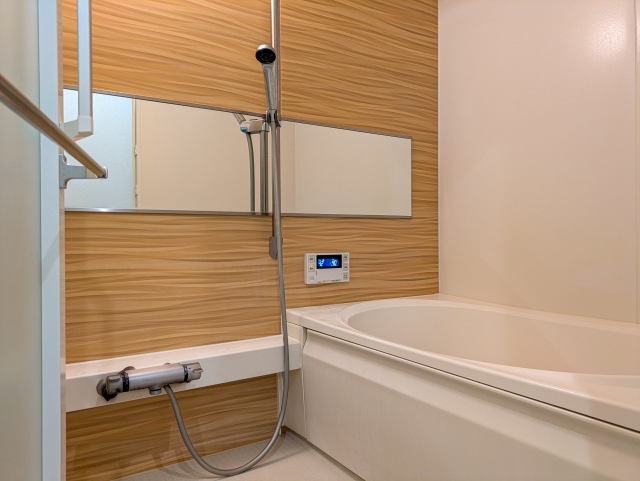 狭いお風呂を広く感じさせる工夫。ワイドミラーと明るい木目パネルのリフォーム例