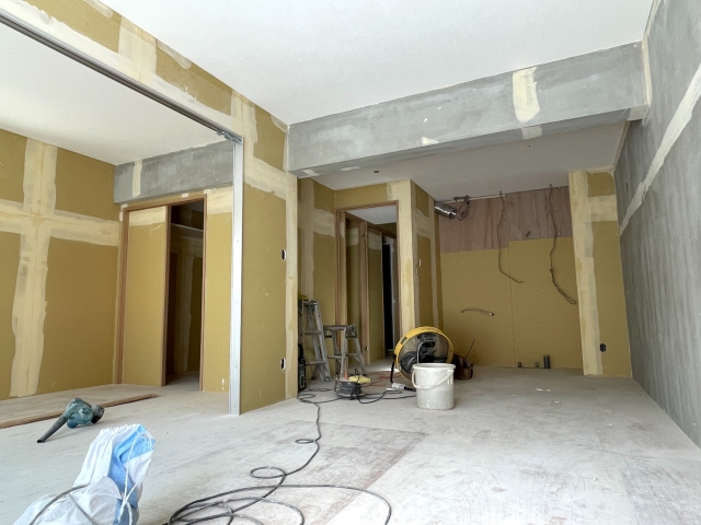 築古マンションのリフォーム工事中の室内。内装を解体し、コンクリート躯体と石膏ボードが露出した状態。間取り変更を伴う大規模リノベーションの施工事例。