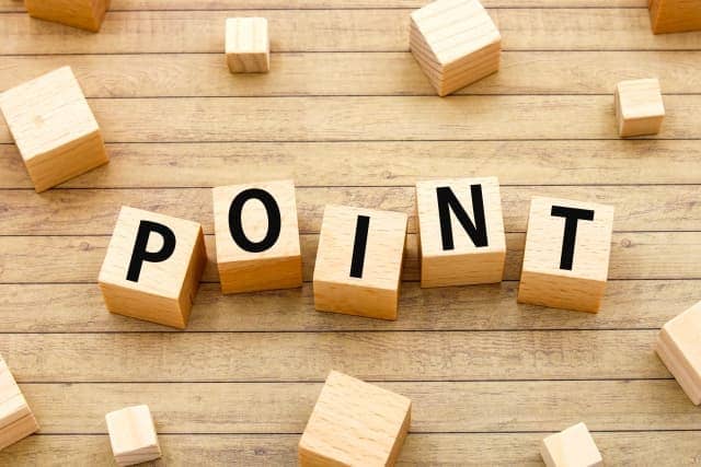 木製テーブルの上に「POINT」の文字が並ぶ木製ブロック。トイレのエコカラット施工業者選びや導入時のポイントを表すイメージ画像。