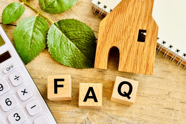 「FAQ」の木製ブロックと電卓・家のオブジェ。玄関へのエコカラット施工やリフォームに関するよくある質問のイメージ画像