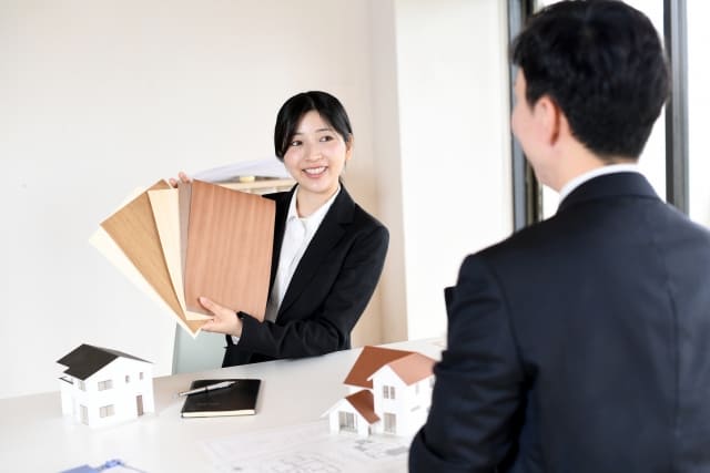 リフォーム業者との打ち合わせで床材のカットサンプルを案内される様子